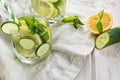 Summer fresh water detox with lemon, cucumber, ice and mint in mason jar on a white wooden background. Rustic. Royalty Free Stock Photo