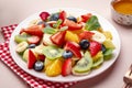 Summer fruit and berry salad with fresh strawberries, blueberries, banana, kiwi, orange and mint, pink background, top view Royalty Free Stock Photo