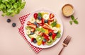 Summer fruit and berry salad with fresh strawberries, blueberries, banana, kiwi, orange and mint, pink background, top view Royalty Free Stock Photo