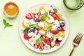 Summer fruit and berry salad with strawberries, blueberries, banana, soft cheese and mint leaves, green background, top view Royalty Free Stock Photo