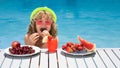 Summer fruit for children. Happy child playing in swimming pool. Kid relaxing on sea beach or pool. Summer kids vacation Royalty Free Stock Photo