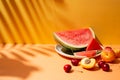 Summer fruit composition with tropical leaves shadows on orange background