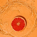 Summer fruit concept citrus red grapefruit on a bright orange background with splashes Royalty Free Stock Photo