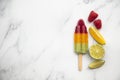 Summer fruit ice lollies made with orange lime and raspberries Royalty Free Stock Photo
