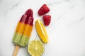 Summer fruit ice lollies made with orange lime and raspberries Royalty Free Stock Photo