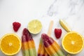 Summer fruit ice lollies made with orange lime and raspberries Royalty Free Stock Photo