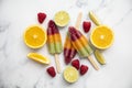 Summer fruit ice lollies made with orange lime and raspberries Royalty Free Stock Photo