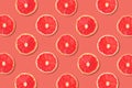 Fruit pattern of pink grapefruit slices on a rose color background Royalty Free Stock Photo