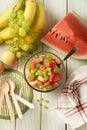 Summer fruit salad in the glass bowl - watermelon, peach, grapes