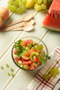 Summer fruit salad in the glass bowl - watermelon, peach, grapes