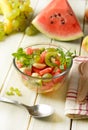 Summer fruit salad in the glass bowl - watermelon, peach, grapes