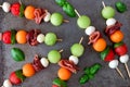 Summer fruit skewers, overhead view on a rustic metallic tray