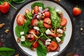 Summer Fruit Strawberry, spinach Salad with walnut, feta cheese balsamic vinegar, kale. in a plate. concepts health food