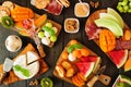 Summer fruit charcuterie table scene against a dark wood background. Overhead view.