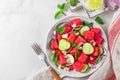 Summer fruit and vegetable salad made of watermelon, cucumber, soft cheese and onion on white table. Top view