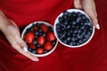 Girl in red dress holding plate of berries. White plate with strawberry and blueberry. Healthy lifestyle. Fruit vitamin. Fruit sal Royalty Free Stock Photo