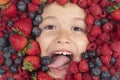 Summer fruits. Assorted mix of strawberry, blueberry, raspberry, blackberry background. Berries closeup near kids face Royalty Free Stock Photo