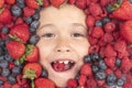 Summer fruits. Berries child face close up. Top view photo of child face with berri. Berry set near kids face. Cute Royalty Free Stock Photo