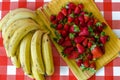 Summer fruits from Israel market, a lot of ripe strawberries and big bunch of yellow bananas Royalty Free Stock Photo