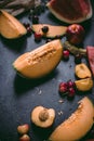 Summer fruits melon, sweet watermelon, rainier cherries, peach on black surface