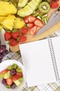 Summer fruits salad bowl, notebook, copy space, vertical Royalty Free Stock Photo