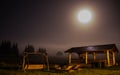 Summer full moon over lodge cabin and trees on foggy mountain highland Royalty Free Stock Photo