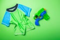 Summer fun concept - water gun and rash guard on bright background