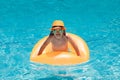 Summer fun kids face. Child boy in swim pool swimming on inflatable ring. Kid swim with orange float. Water toy, healthy Royalty Free Stock Photo