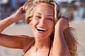 Summer fun. Portrait of an attractive young blonde woman in a bikini laughing while at the beach. Royalty Free Stock Photo