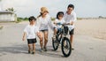 Summer fun by sea, Happy parents guide their children in learning to ride Royalty Free Stock Photo