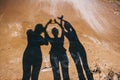 Summer fun. Shadow of a beautiful family having fun on the beach at sunset by the sea Royalty Free Stock Photo