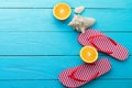 Summer fun time and flip flops. Sea shell. Slippers and orange fruit on blue wooden background. Mock up and picturesque. Top view. Royalty Free Stock Photo