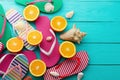 Summer fun time and flip flops. Sea shell. Slippers and orange fruit on blue wooden background. Mock up Top view. Royalty Free Stock Photo