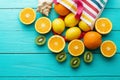 Summer fun time and fruits on blue wooden background. Mock up and picturesque. Orange, lemon, kiwi fruit in bag and shell Royalty Free Stock Photo