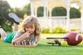 Summer games and outdoor activities for kids. Child playing chess game in spring backyard, laying on grass. Concentrated Royalty Free Stock Photo