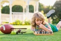 Summer games and outdoor activities for kids. Child playing chess game in spring backyard, laying on grass. Concentrated Royalty Free Stock Photo