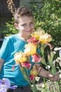 In the summer in the garden boy standing near flowers irises. Royalty Free Stock Photo