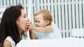 summer, in the garden, a funny one-year-old blonde girl treats her mother with watermelon, feeds her from her hands, the Royalty Free Stock Photo