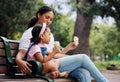 Summer, garden and ice cream with a mother and daughter bonding together while sitting on a bench outdoor in nature Royalty Free Stock Photo