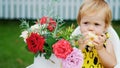 summer, in the garden. portrait, one year old pretty blond girl eating an apple with apetite. on the table, there is a Royalty Free Stock Photo