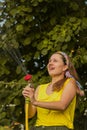 Summer garden, watering - beautiful girl watering roses with garden hose in the garden Royalty Free Stock Photo