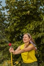 Summer garden, watering - beautiful girl watering roses with garden hose in the garden