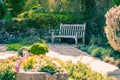 Summer garden with wooden bench, decorative stones and spring gr