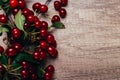 Summer gifts. a fresh branch of a cherry tree with green leaves and red fruits, cherries lying on a wooden table, on a wooden back Royalty Free Stock Photo