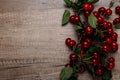 Summer gifts. a fresh branch of a cherry tree with green leaves and red fruits, cherries lying on a wooden table, on a wooden back Royalty Free Stock Photo