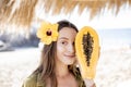 Summer girl with papaya fruit at the beach resort