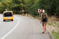 Summer girl in short shorts walks on the side of an asphalt road