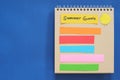 Summer goals concept. Checklist of goals in note pad in blue background with copy space.