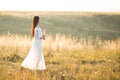 Summer is a great dream time. Beautiful girl in white dress running on the autumn field of wheat at sunset time Royalty Free Stock Photo