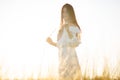 Summer is a great dream time. Beautiful girl in white dress running on the autumn field of wheat at sunset time. Royalty Free Stock Photo